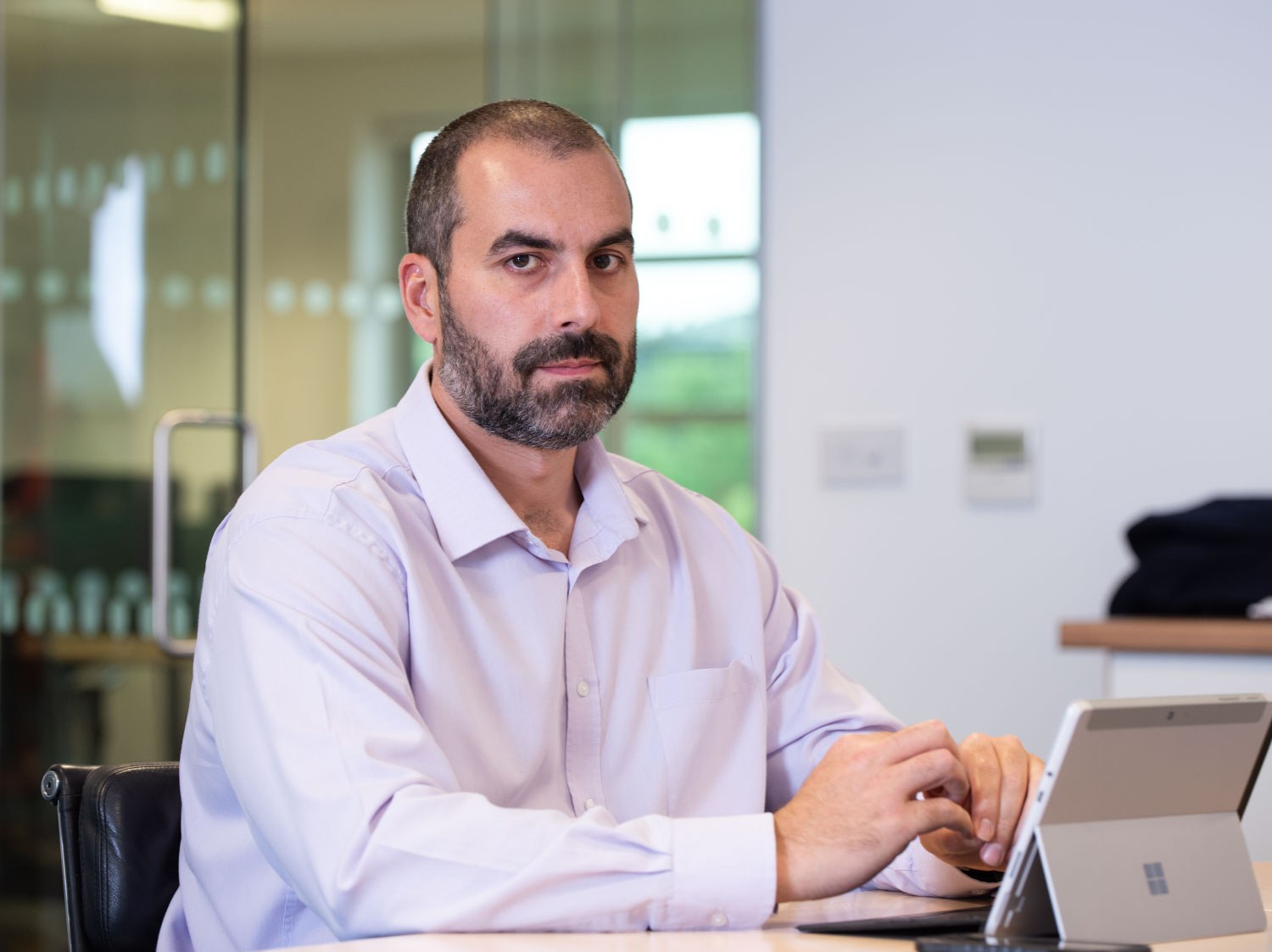 Business portrait of a man working at a tablet in a bright modern office in Cardiff