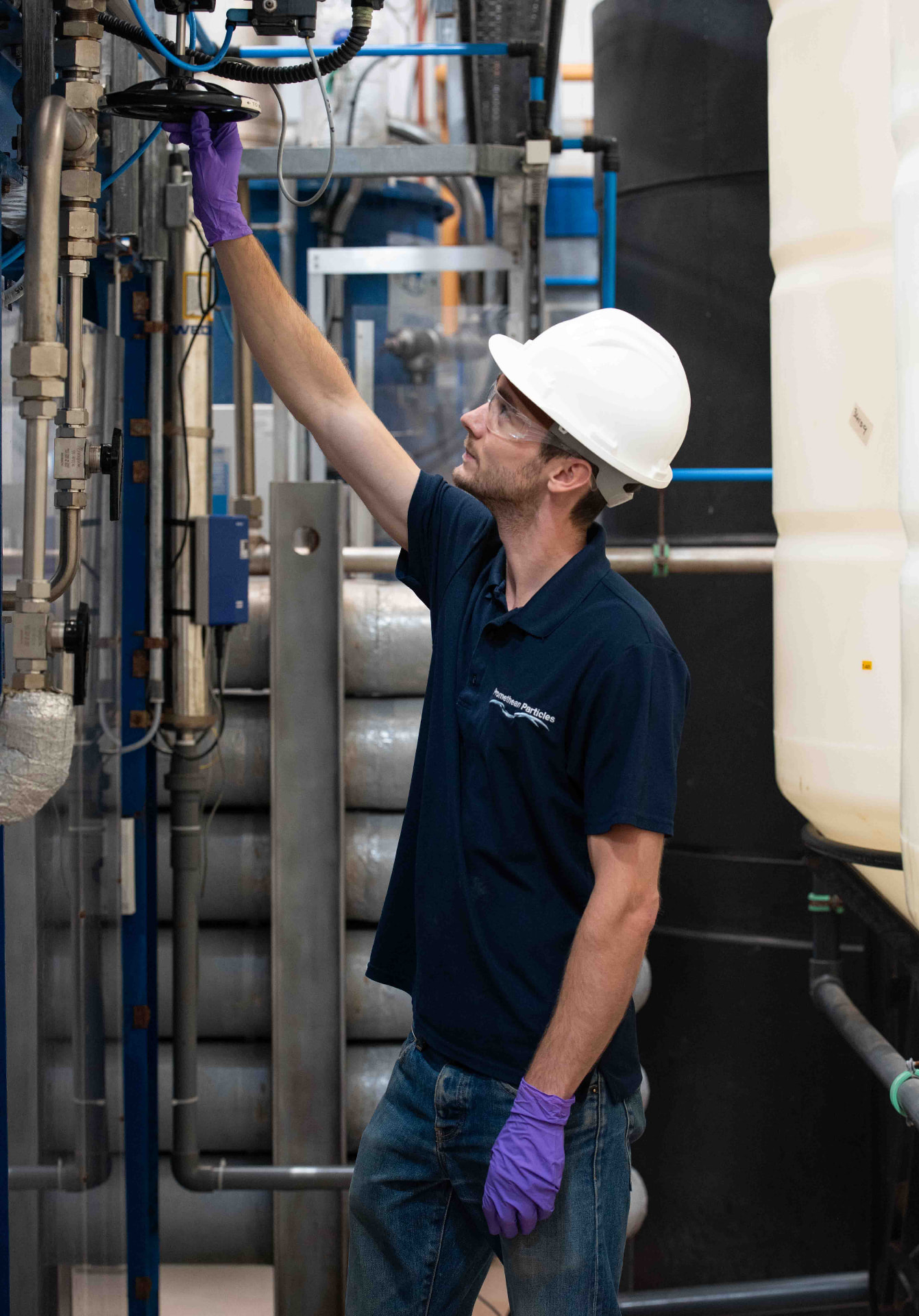 Engineer in a hard hat adjusting a valve during industrial photography at a process plant