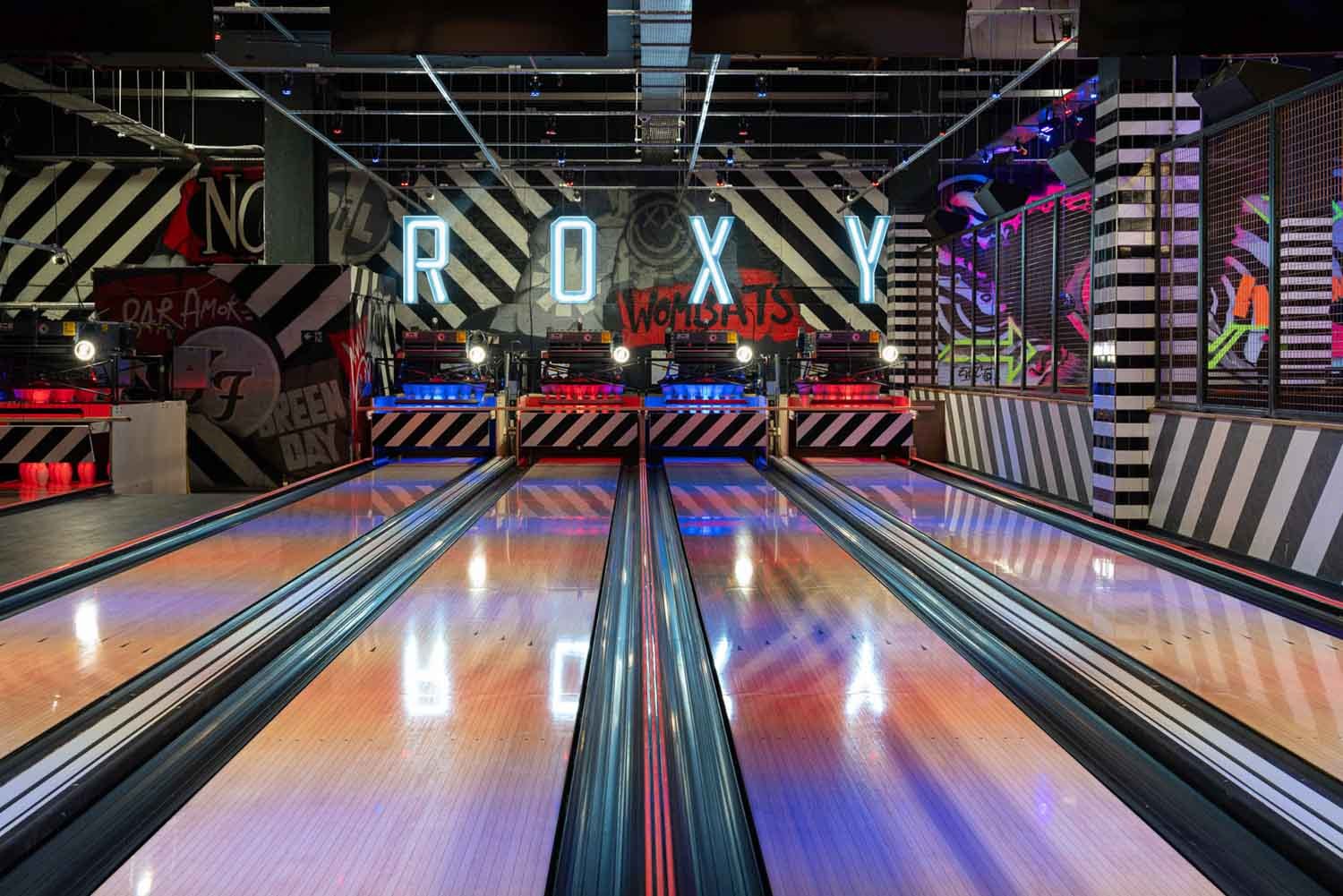 Neon-lit bowling lanes photographed inside a rock-themed entertainment venue in South Wales