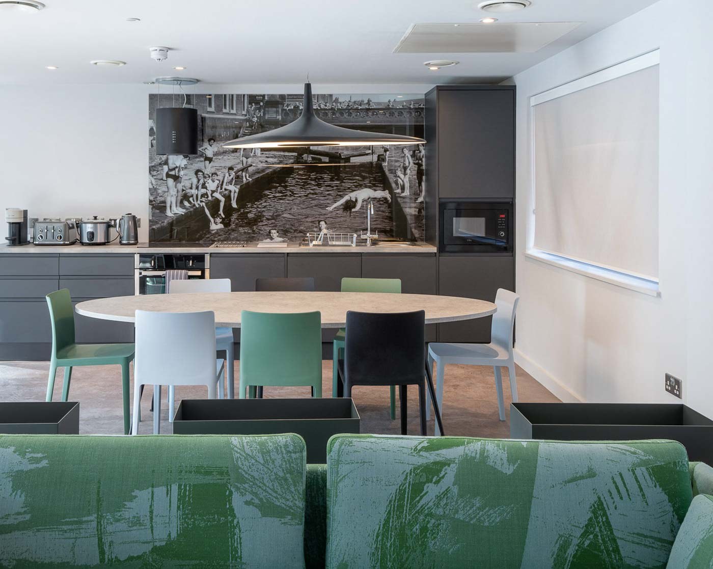 Interior photography of a modern residential lounge and kitchen with a large monochrome mural