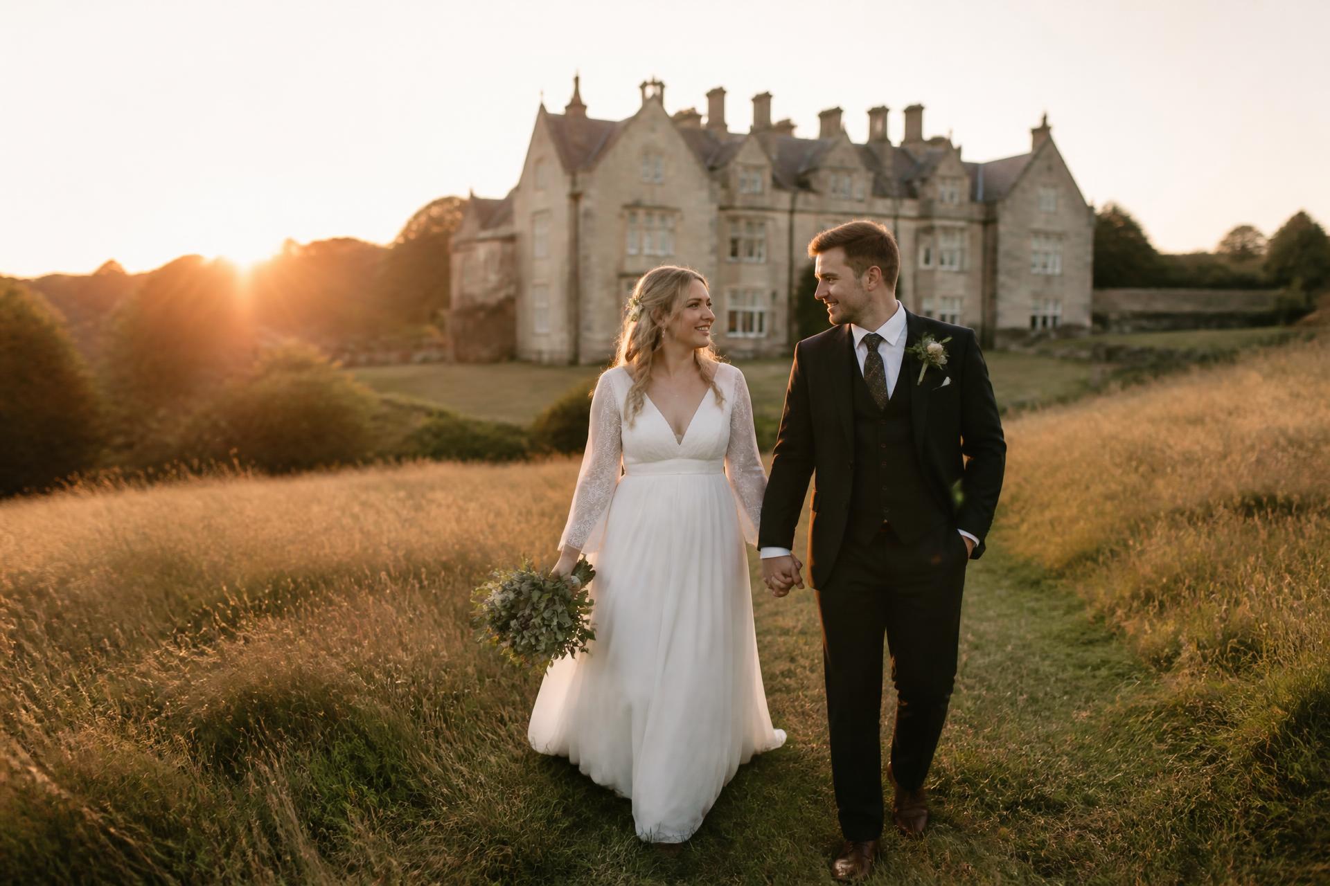 Bride and groom walking through a meadow at golden hour during a South Wales wedding